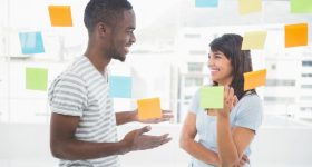 Happy coworkers standing and interacting together in the office