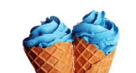 Vanilla frozen yogurt or colorful soft ice cream in waffle cone