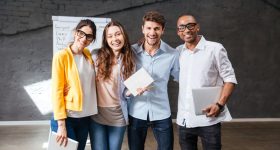 Multiethnic group of happy young business people standing in office