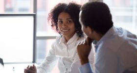 African american colleagues businessman and businesswoman talking in office