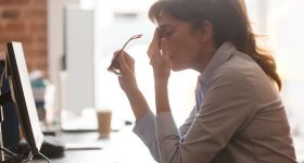 Tired female employee suffer from headache at workplace