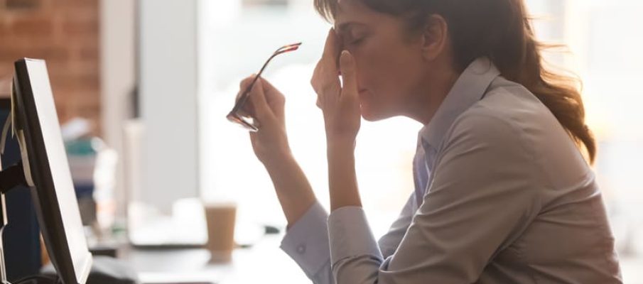 Tired female employee suffer from headache at workplace