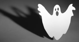 Halloween background concept. Funny ghost doing boo gesture and