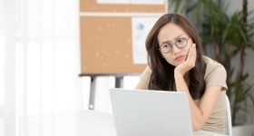 Asian woman thinking hard concerned about online problem.