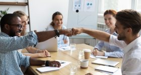 Guys fist bumping congratulating each other with success at work